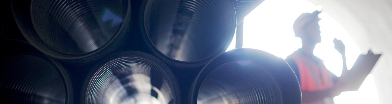 Man standing next to pipes