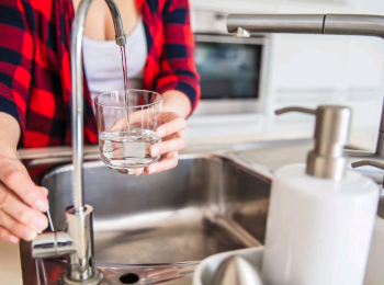 Woman filling glass with tap water