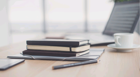 Books, laptop and cuppa on desk