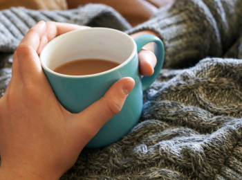 A cuppa being held by person wearing a jumper