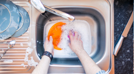 Washing dishes in bowl in sink