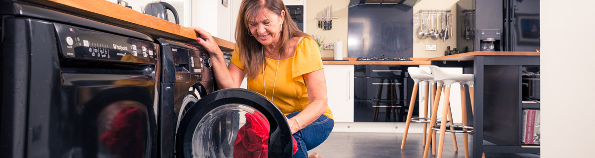 woman filling washing machine with clothes