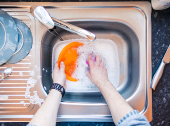 Washing dishes in bowl in sink