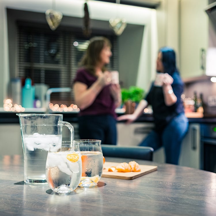 jug of water with glasses and orange slices