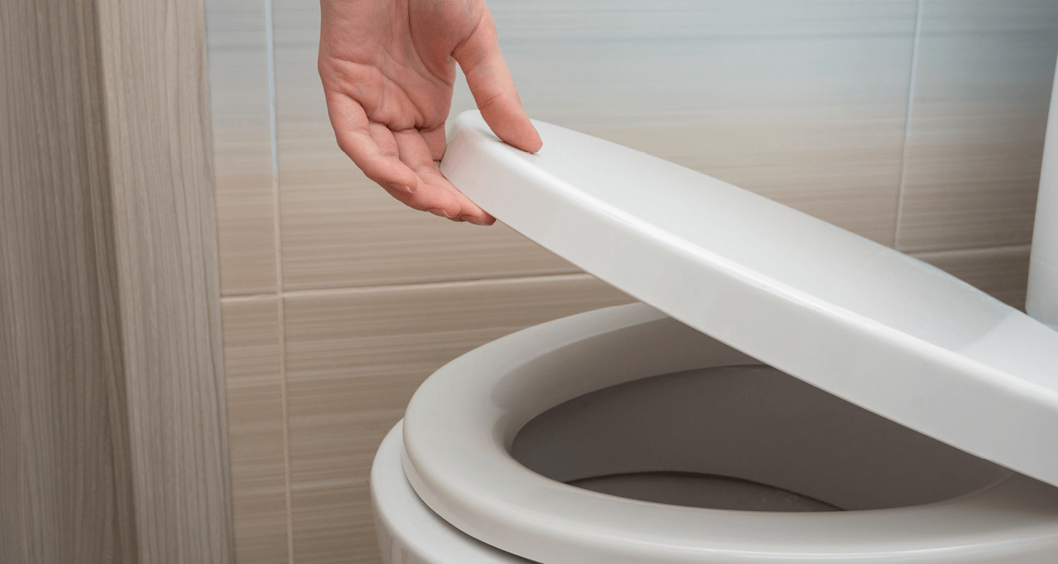 Person lifting toilet seat up