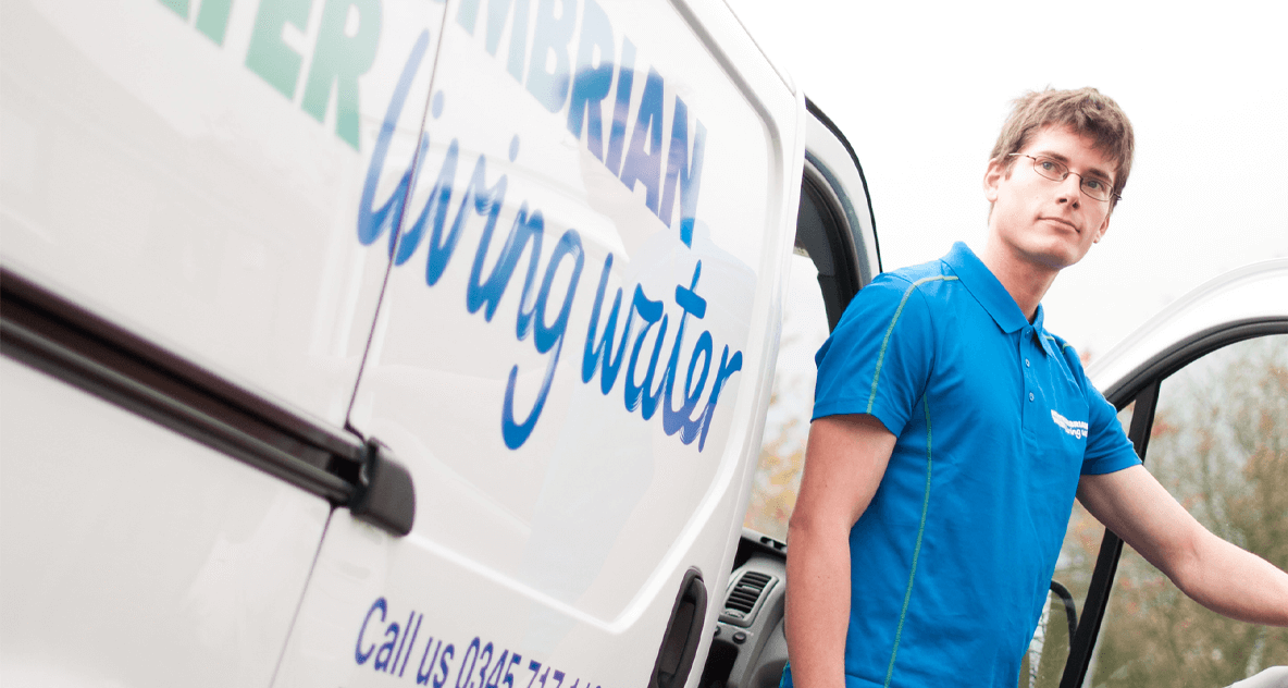 Northumbrian Water employee in blue polo shirt next to van