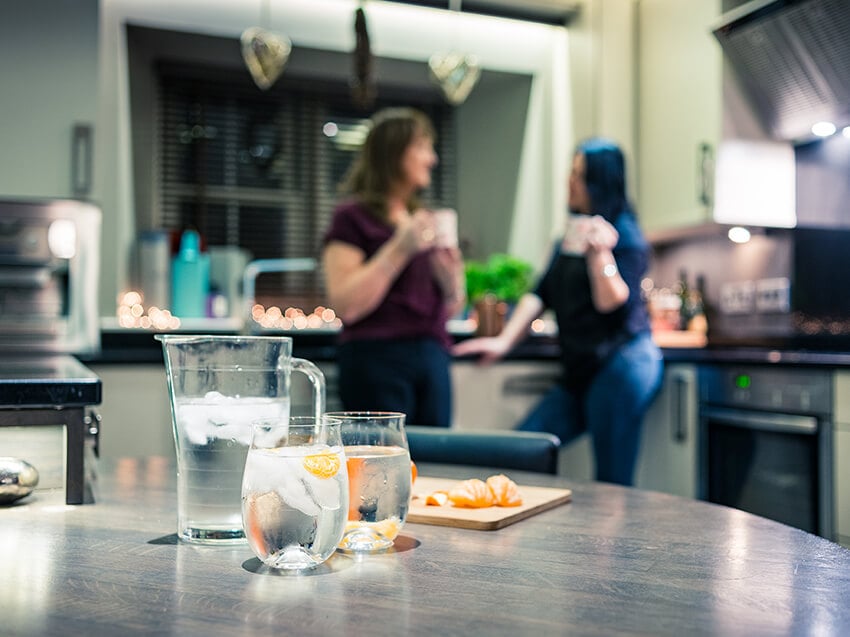Jug of water with two glasses and orange pieces